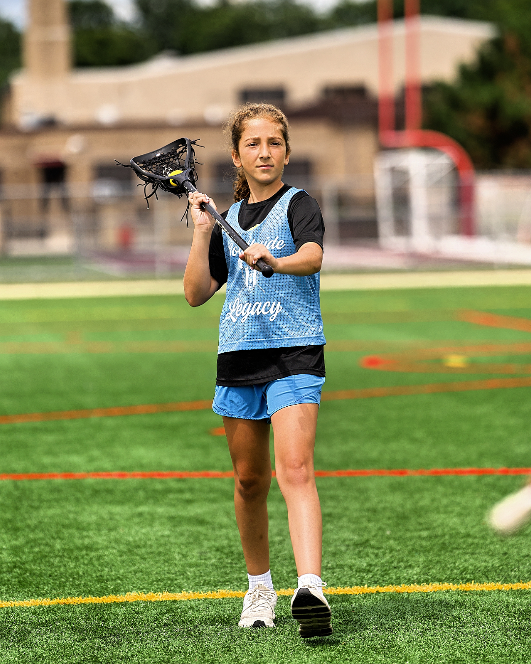 Youth lacrosse players practicing on turf